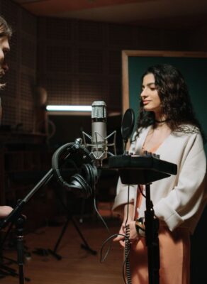 Twee mensen nemen geluid op in een professionele geluidsstudio