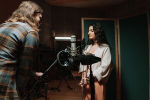 Twee mensen nemen geluid op in een professionele geluidsstudio