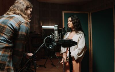 Twee mensen nemen geluid op in een professionele geluidsstudio