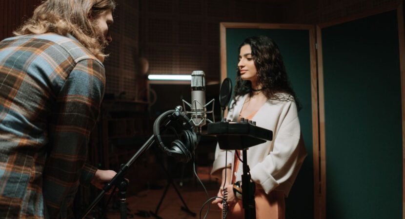 Twee mensen nemen geluid op in een professionele geluidsstudio