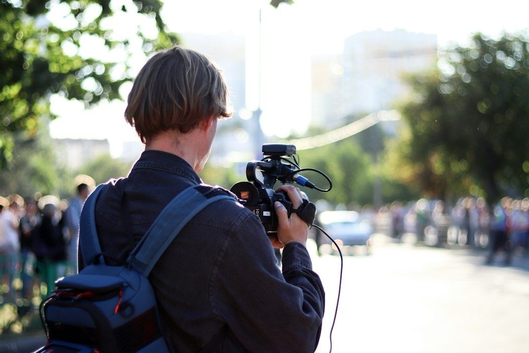 Cameraman filmt met een handcamera op een drukke stadsstraat