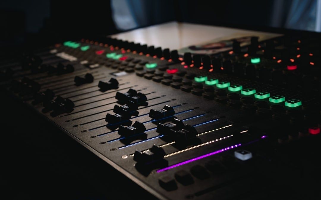 Close-up van een verlichte audiomengtafel in een donkere studio